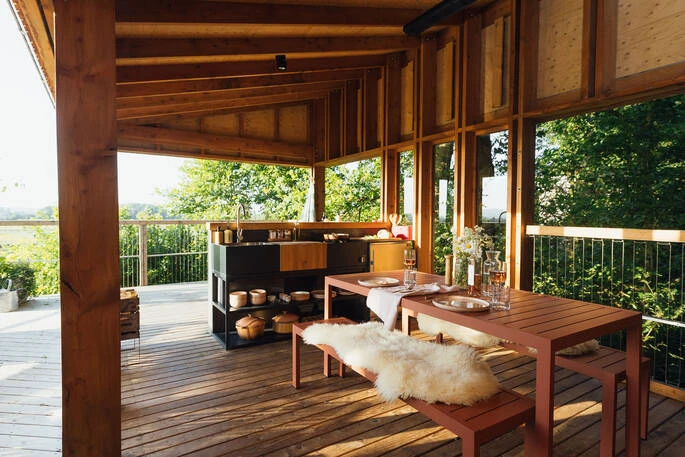 An open-shelf kitchen, dining benches and exposed rafters.